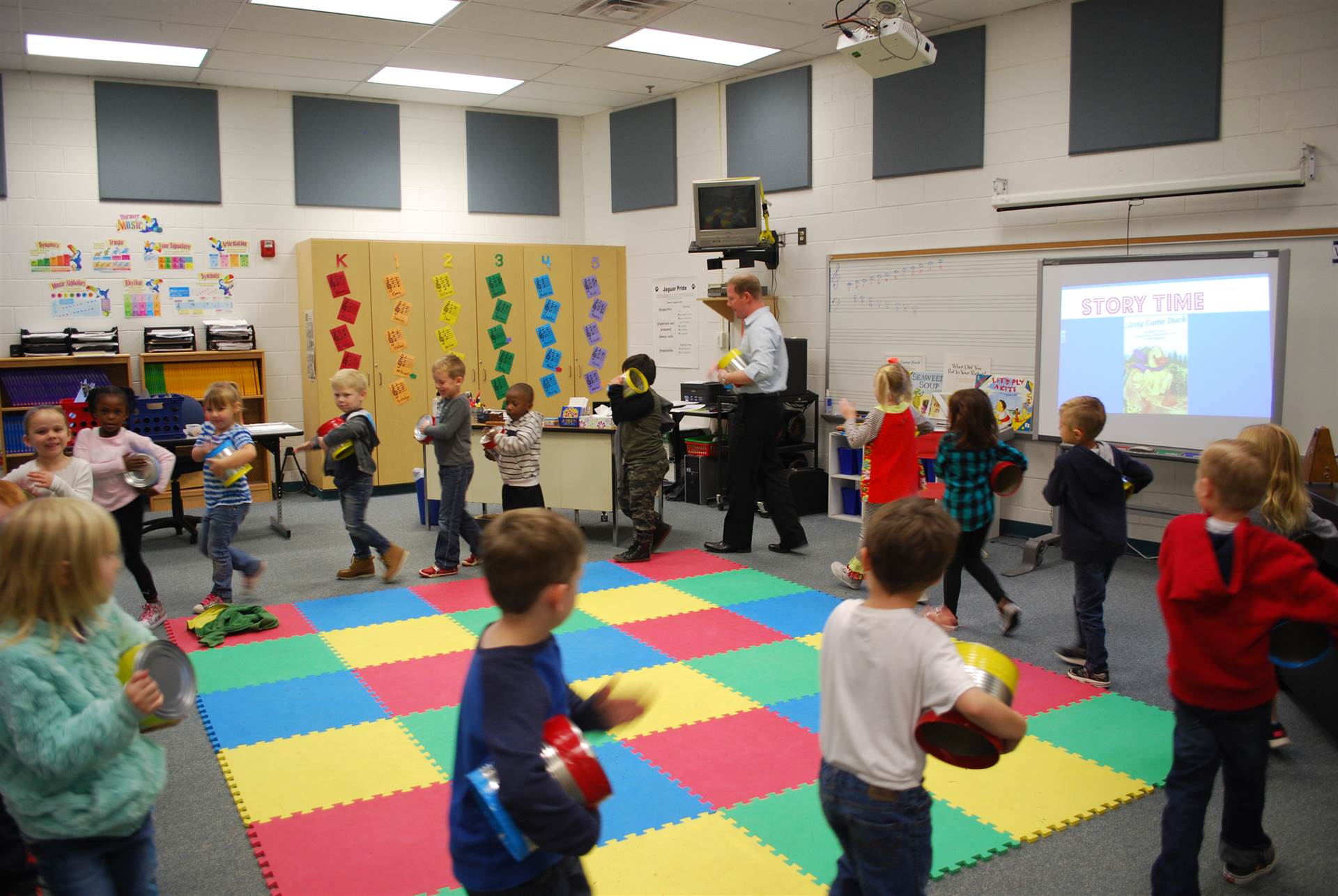 Students walking in a circle playing drums in art class. 